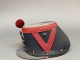 a small hat with a red ribbon on it