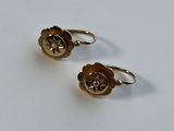 une paire de boucles d'oreilles dorées ornées d'un motif floral