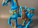 statue of a blue horse on a blue base with a brown mane