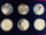 six coins in a blue box with a yellow stick in it