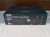 a box of vacuum cleaner sitting on a bed