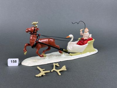 a figurine of a dog pulling a sleigh with a man on it