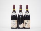 trois bouteilles de vin sont posées sur une surface blanche