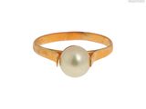 un gros plan d'une bague en perle sur fond blanc