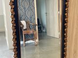 un grand miroir posé par terre à côté d'une chaise