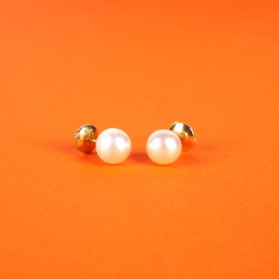une paire de boucles d'oreilles en perles sur fond orange