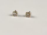 a pair of diamond stud earrings on a white surface