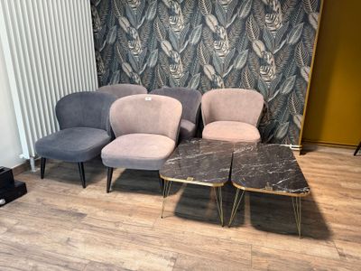trois chaises et une table dans une pièce dont l'un des murs est tapissé