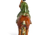 a figurine of a man riding a horse with a bird on its back