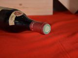 a bottle of wine sitting on a red table cloth