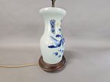 a white vase with blue flowers on it on a table