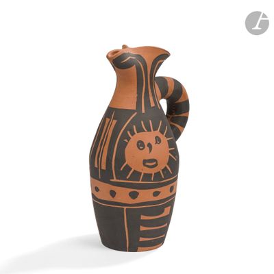 un vase noir et orange orné d'un motif représentant un soleil