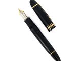 un stylo noir et une bordure dorée sur fond blanc
