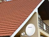 une photo d'une maison avec une antenne parabolique sur le toit