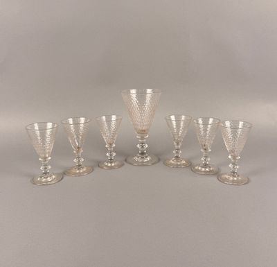 six verres à pied en verre transparent bordés d'argent, posés sur un support blanc