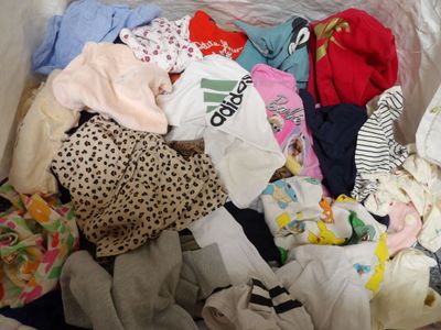 a white box filled with clothes and a teddy bear