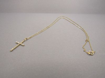 Gros plan sur un collier en or orné d'une croix