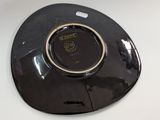 a black plate with a gold rim on a white table