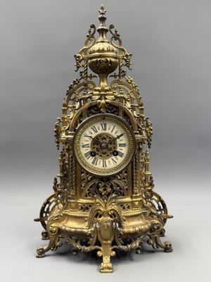 a gold clock sitting on top of a table