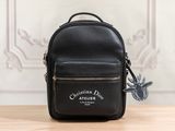 a small black backpack with a bird on it sitting on top of a table