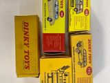 four boxes of dinky toys sitting on top of a white table