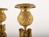 two gold vases sitting next to each other on a table