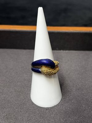 un cône blanc orné d'un anneau bleu et doré