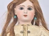 doll with long red hair wearing a gold dress and turquoise earrings
