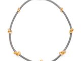 un collier gris et doré avec des perles dorées sur fond blanc