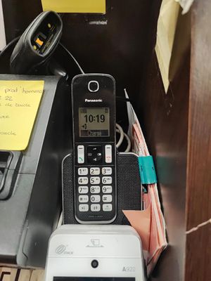 a cell phone sitting on top of a desk next to a telephone