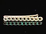 une barrette plaquée or ornée d'un motif tressé