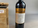 a bottle of wine sitting next to a wooden box