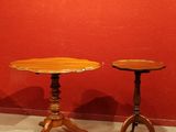 Deux petites tables au plateau en bois sont disposées devant un mur rouge.