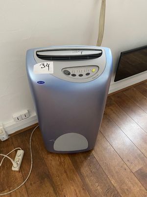 un petit purificateur d'air posé au sol près d'un mur