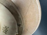 a brown bowl with writing on it sitting on a table
