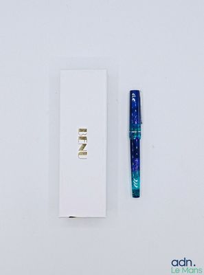 un stylo posé à côté d'une boîte blanche