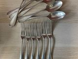 a lot of spoons and forks laid out on a table