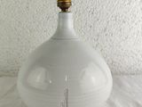 a white vase with a gold top sitting on a table