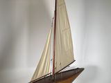 a model of a sailboat on a wooden stand