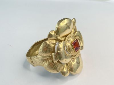 une image représentant une bague en or ornée d'une grenat au centre