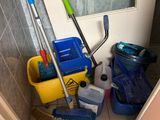 brooms, mops, buckets, and other cleaning supplies in a bathroom
