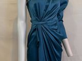 un mannequin vêtu d'une robe bleue, posé sur un socle