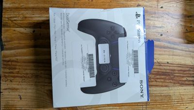 the box is open on a wooden table with a game controller