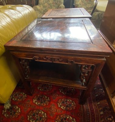 une table en bois avec un plateau en verre, posée sur un tapis rouge