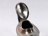 a silver vase with a lid on a white surface