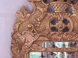 a mirror with a gold frame and a chandelier in front of a window