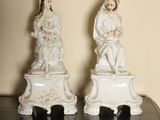 two figurines of a man and a woman on top of a table