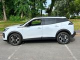 the white suv is parked in a parking lot with trees in the background