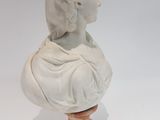 white marble bust of a woman on a wooden base