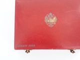an old red leather case with a gold emblem on it